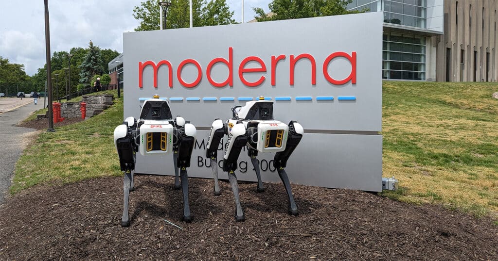 Two Spot robots equipped for perimeter security applications in front of a Moderna office.