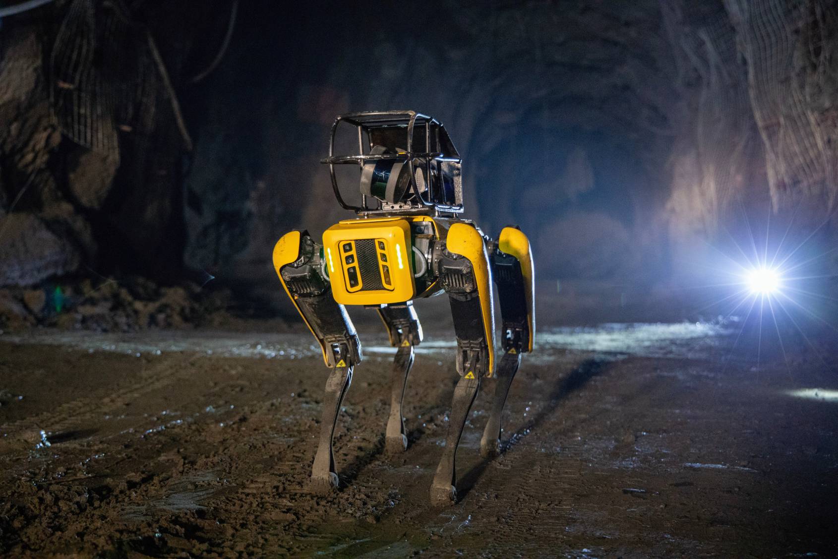 Spot with payloads in a dimly lit mine tunnel