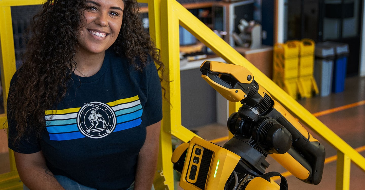 A young employee poses with Spot