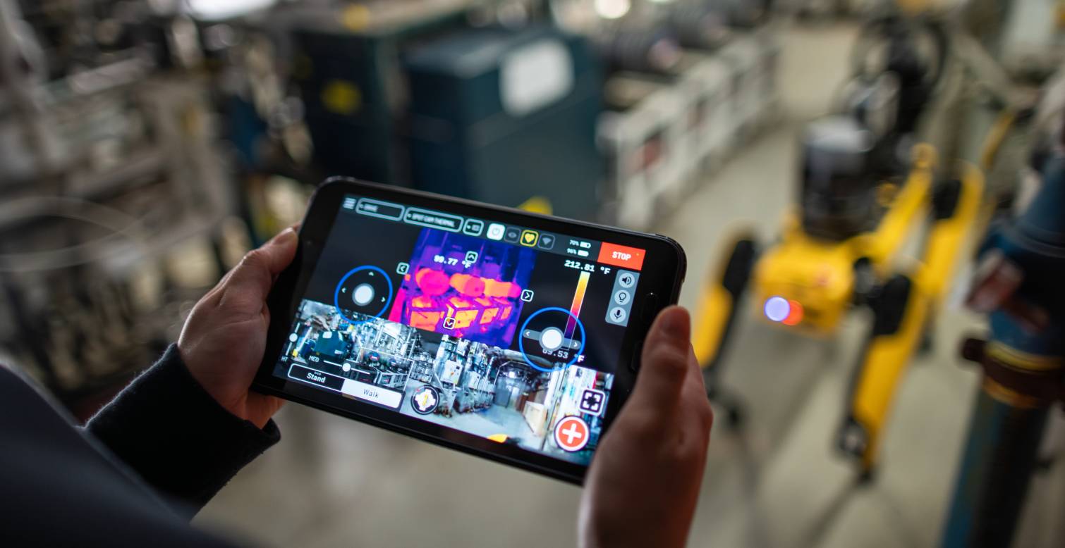 An operator uses a tablet controller to take a thermal image of motors