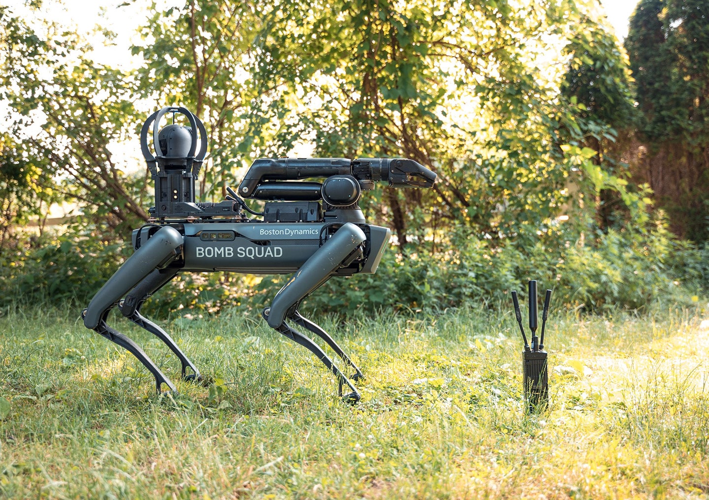 A Spot robot with an arm and a label reading "Bomb Squad" next to a Persistent Systems radio