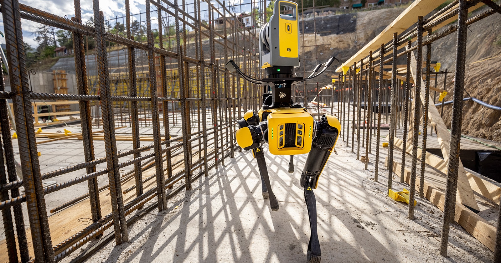 Spot walks through rebar framing on a construction site