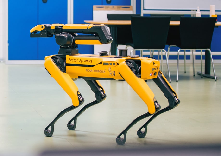 The Spot robot equipped with an arm stands in a Novo Nordisk facility