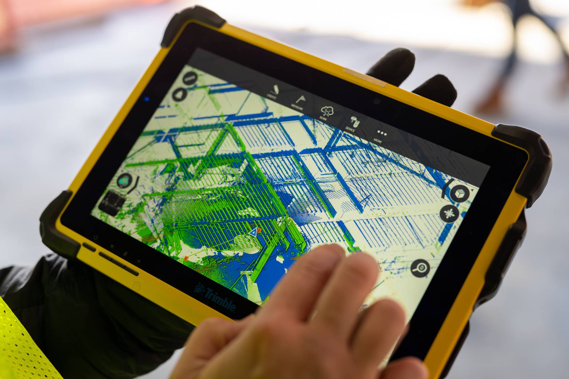 A worker using a tablet to analyze a 3D map of a jobsite