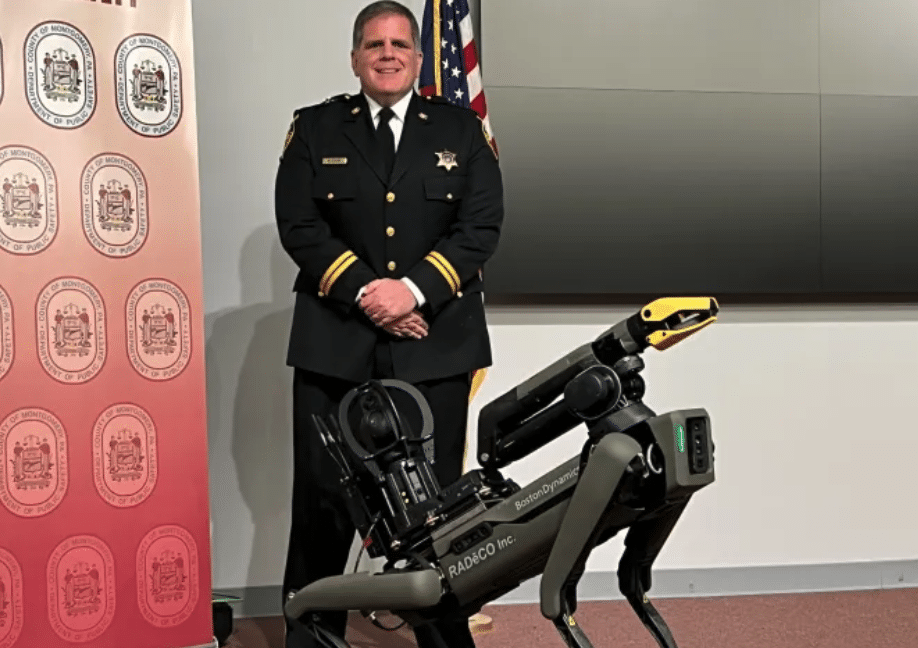 A police representative in a formal uniform poses with Spot